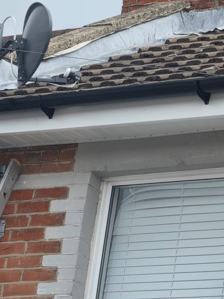 Close-up of new white uPVC soffit and fascia with black guttering above a window in Portsmouth